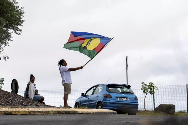 Une femme kanake brandissant un drapeau à Nouméa, en Nouvelle-Calédonie